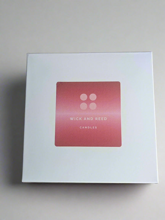 White box with a pink label featuring 'Wick and Reed' on a white surface